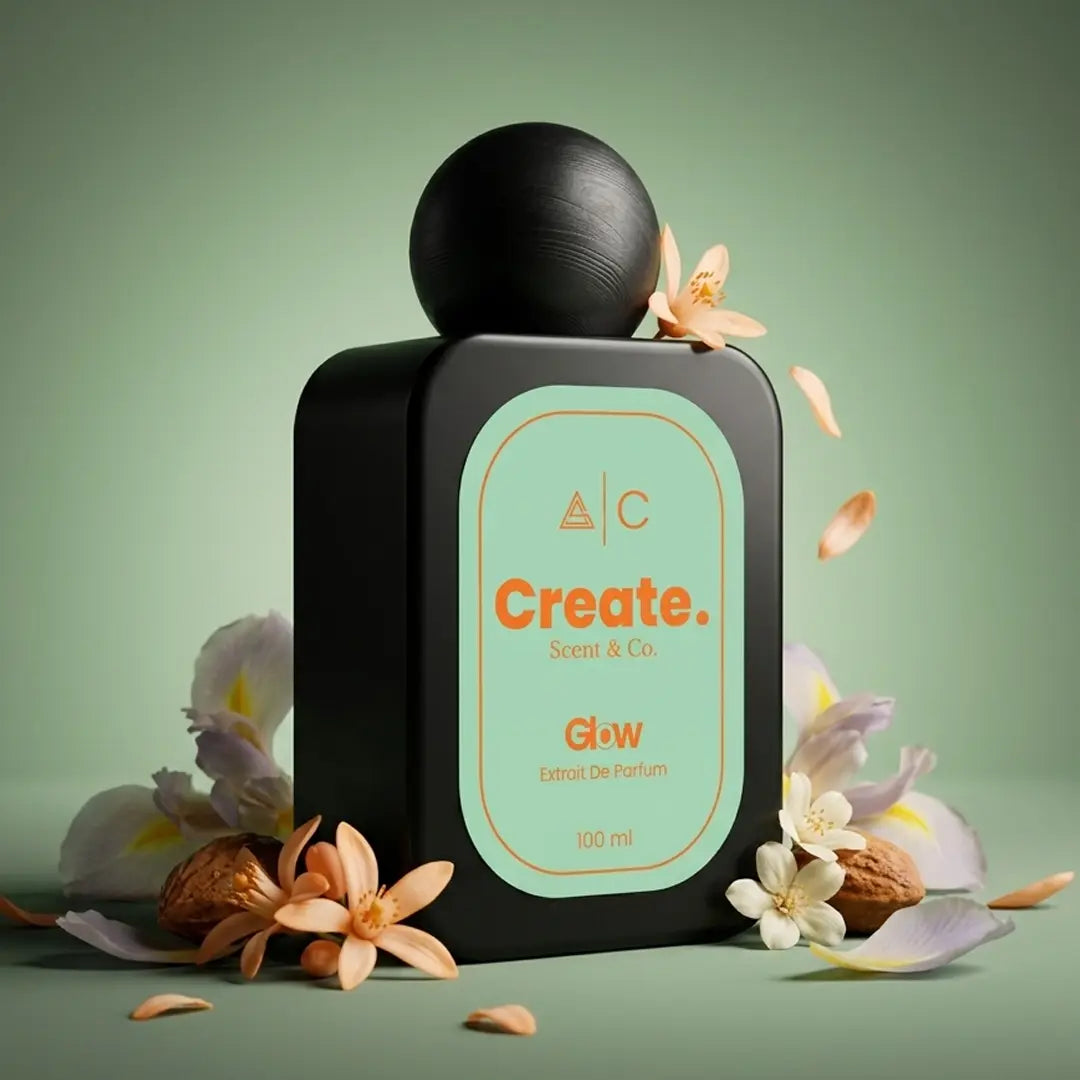 Create. Scent & Co. Glow Extrait De Parfum 100ml surrounded by orange blossom petals, white flowers and nutmeg on a soft sage green background