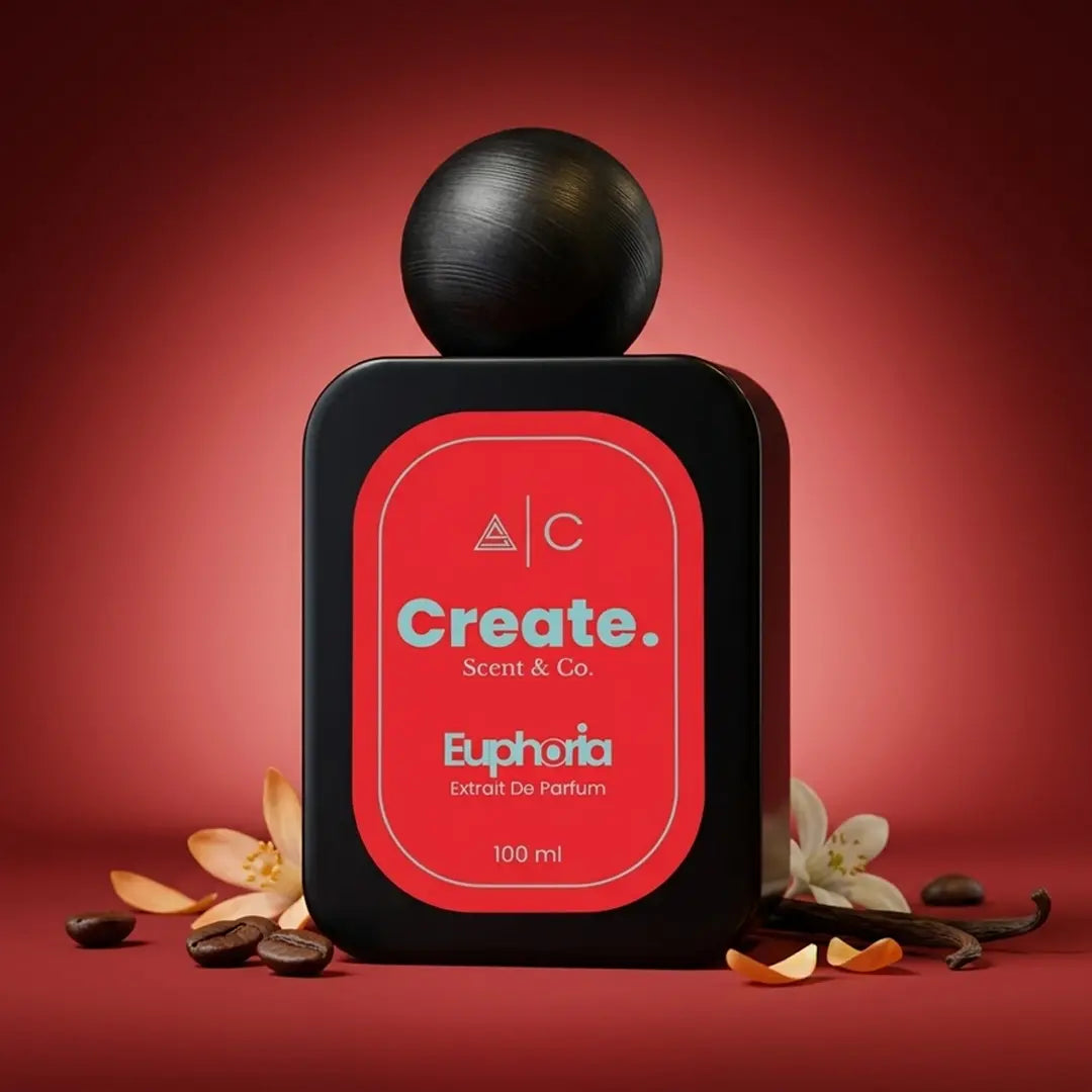 Create. Scent & Co. Euphoria Extrait De Parfum 100ml with roasted coffee beans, orange blossom and vanilla pod arranged on a deep crimson background